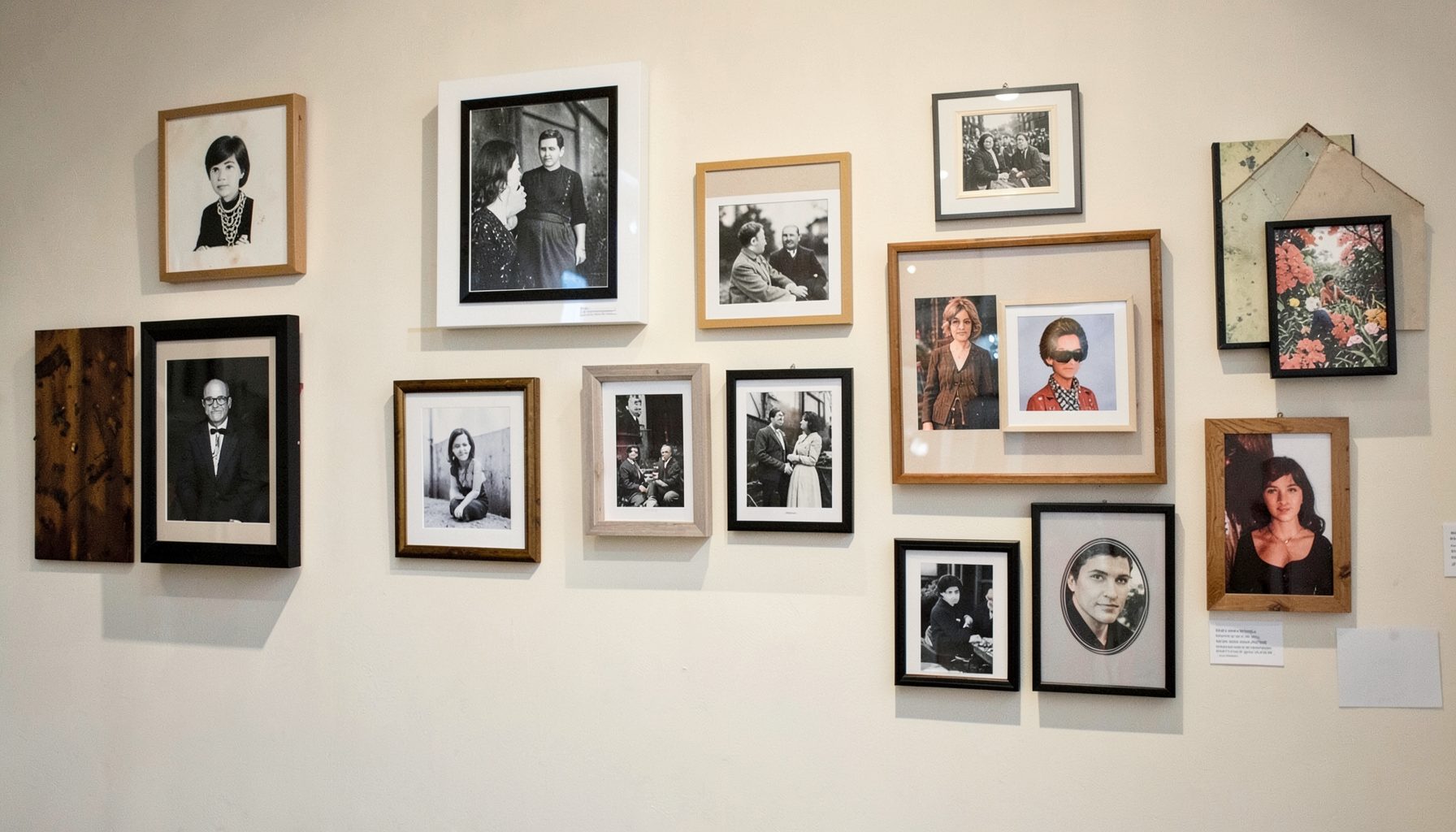 A gallery wall in progress with an eclectic mix of framed art and photographs being rearranged on a light-colored wall